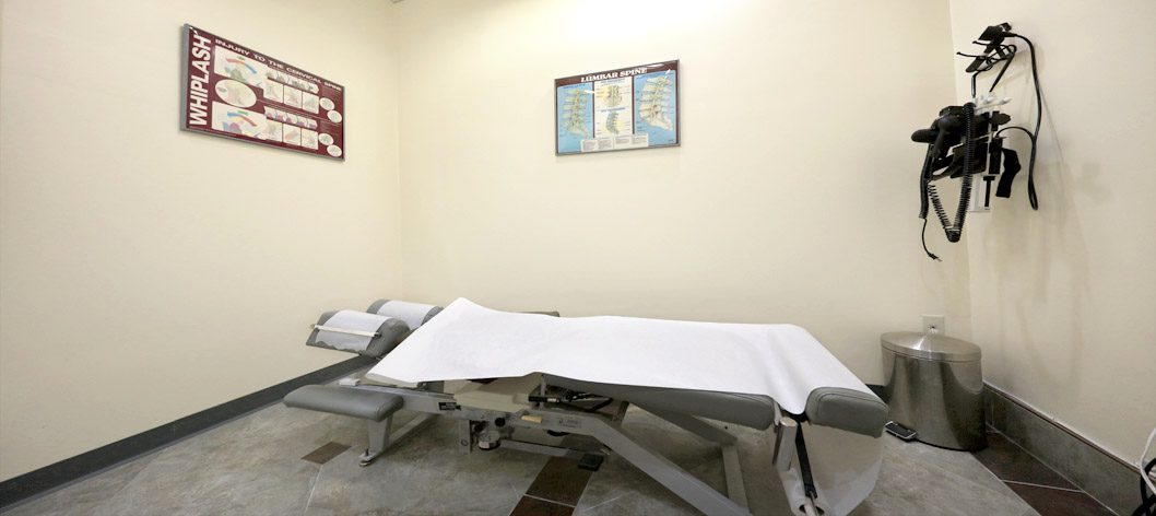 Treatment room with adjusting table and spine posters